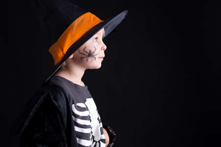 Child, dressed for Halloween, playing at home, isolated image on black backgroundの写真素材
