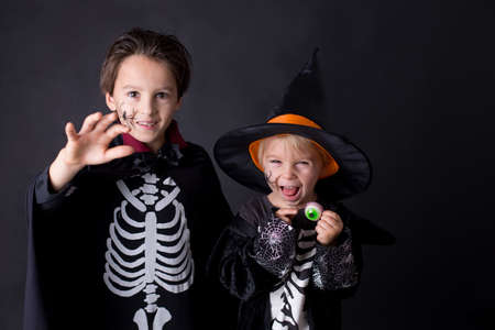 Children. brothers, dressed for Halloween, playing at home, isolated image on blackの写真素材