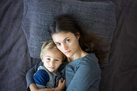 Young mother, hugging her child in bed, positive emotion, love, happiness, peace, isolated