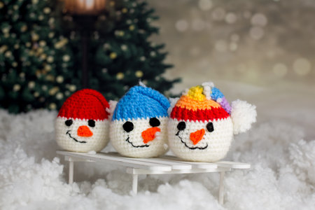 Little cute handmade snowman head with colorful hats on a sledge in the snowの写真素材