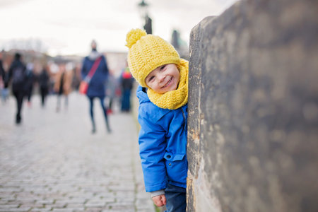 Cute child, boy with family, having a walk in Prague on Charles bridge wintertimeの写真素材