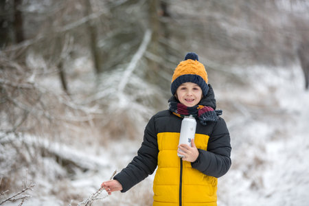 Cute child, playing in winter forest during a cold snowy dayの写真素材