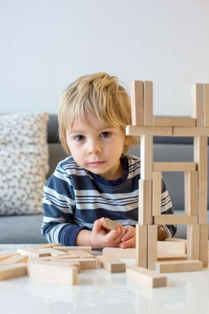 Toddler child, playing with wooden puzzle at homeの写真素材