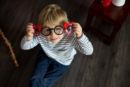 Cute toddler blond child, cute boy with valentine decoration, love, flowers, cake in studioの写真素材