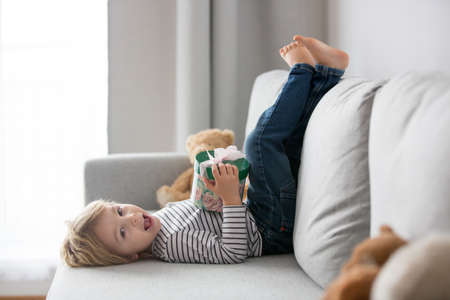 Sweet toddler blond child, baby boy, holding box with a little gift for mom for mothers dayの写真素材