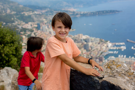 Family, looking at the view of Monaco from La Turbie, standing on top of the rocksの写真素材