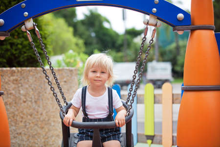 Sweet toddler child, boy, playing on the playground summertimeの写真素材