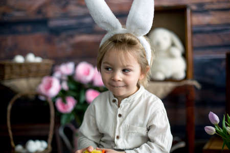 Cute toddler blond child, boy with easter decoration in studio
