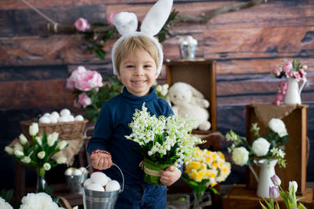 Cute toddler blond child, boy with easter decoration in studioの写真素材