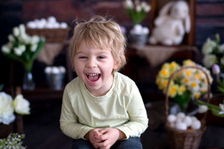 Cute toddler blond child, boy with easter decoration in studioの写真素材