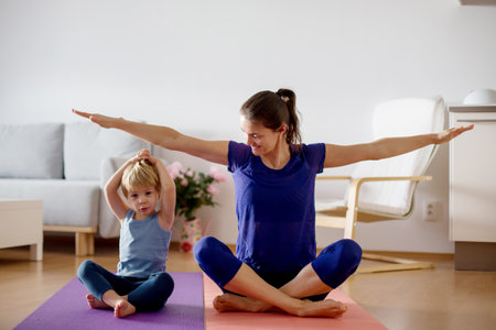 Mother and children, exersizing at home during coronavirus, people making gymnastic at home, while fitness centers are closedの写真素材