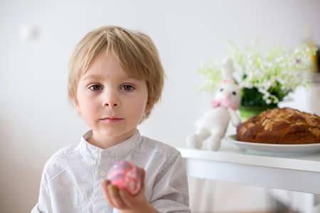 Children, boy siblings, coloring eggs for Easter at home