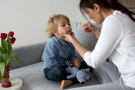 Mother, testing her child for covid at home, making home allowed swab tests to prove negative resultの写真素材
