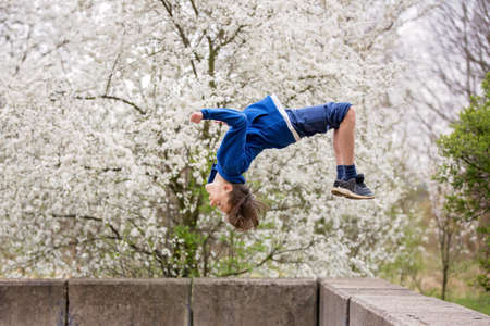 Teen child, boy, making summersaults in the park, springtimeの写真素材