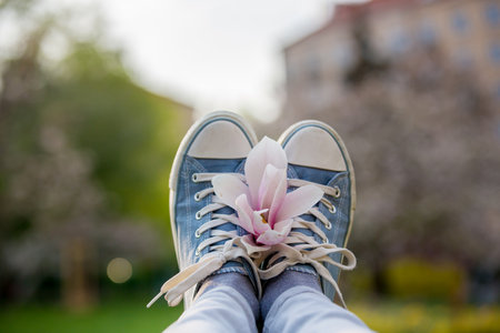 Woman's shoes on her feet and a beatiful magnolia flower, blurred background