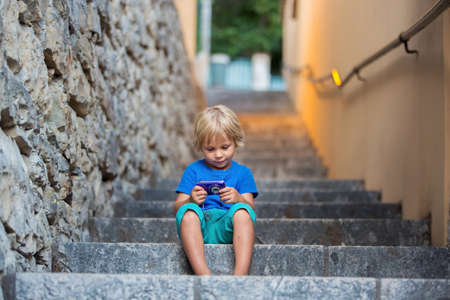 Happy beautiful children, boys, playing on stone staircasechild, kid, toddler, camera, small,...