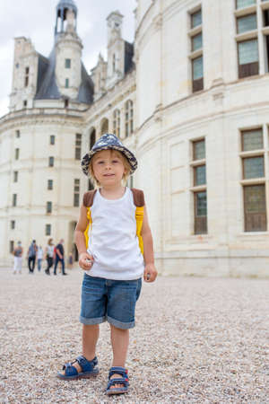Happy children walking on the premises of Chambord castle on Loire valley in France on a summer dayの写真素材