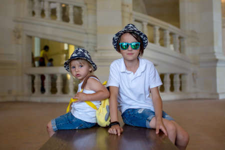 Happy children walking on the premises of Chambord castle on Loire valley in France on a summer dayの写真素材