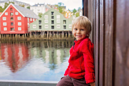 Cute child, boy, visiting Trondheim, Norway during the summer, enjoying the cityの写真素材