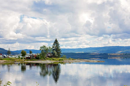 Beautiful landcape in Norway, amazing scandinavian nature with fjords, small red cabins and beautiful mountainsの写真素材