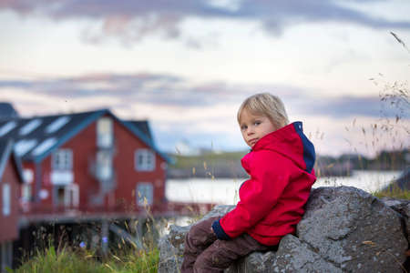 Cute little child, enjoying the view in small A village on the end of Lofoty, the village with the shortest name, Norwayの写真素材