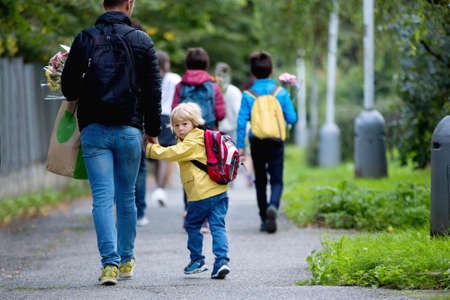 Happy children, going to school in the morning, first day, caring bouquet of flowers for the teacher, walking togetherの写真素材