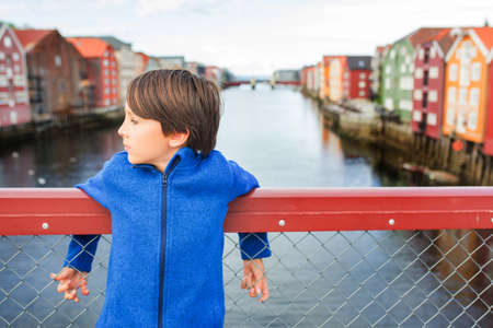 Cute child, boy, visiting Trondheim, Norway during the summer, enjoying the cityの写真素材