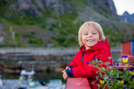 Cute little child, enjoying the view in small A village on the end of Lofoty, the village with the shortest name, Norwayの写真素材