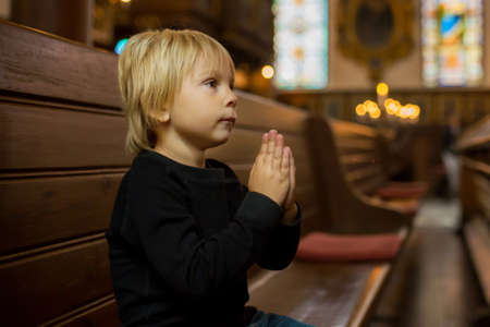Little child, boy, praying in church, cathedrale in Stockholm, Swedenの写真素材