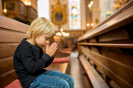 Little child, boy, praying in church, cathedrale in Stockholm, Swedenの写真素材