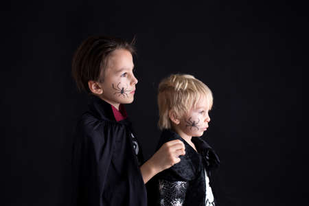 Children. brothers, dressed for Halloween, playing at home, isolated image on blackの写真素材