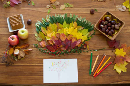 Sweet child, boy, applying leaves using glue while doing arts and chraft with leaves autumn at home,...