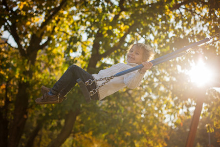 Happy children, playing with pet dog in autumn park on a sunny day, foliage and leaves all around themの写真素材