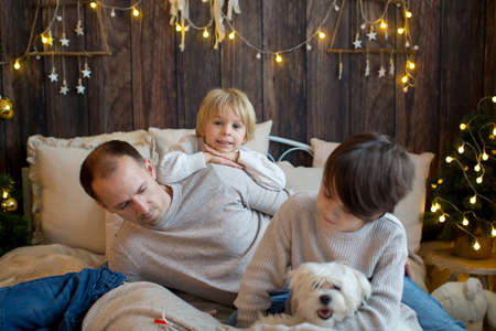 Happy family with children and pet dog, enjoying Christmas time together, celebrating christmasの写真素材