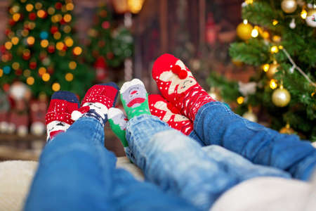 Happy family, lying on bed with christmas socks, enjoying happy day togetherの写真素材