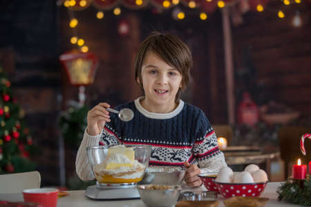 Preteen child, preparing his first cookies, made alone, baking christmas cookies at home, having funの写真素材