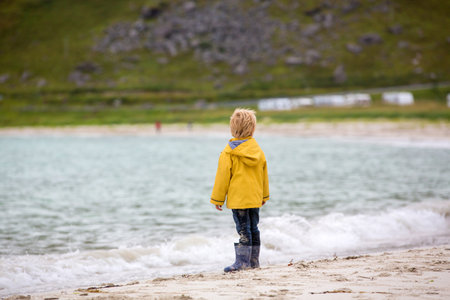 Cute child, running on a Norway white sand beach in the summerの写真素材