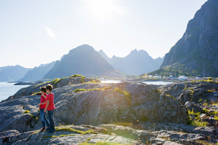 Happy family, enjoying the pier in Sorvagen, Lofoten island, Norway. Children, running on a sunny day on the rocks, enjoying good weatherの写真素材