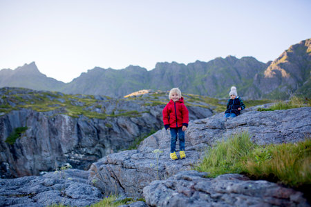 People, enjoying beautiful view of norwegian mountains near A village on a sunny evening, Lofoten, northern Norwayの写真素材