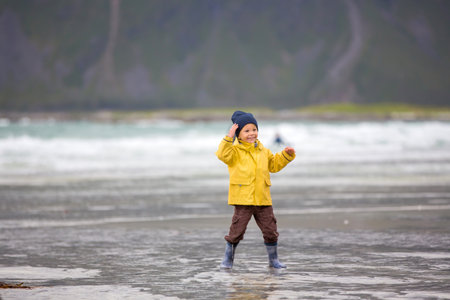 Cute child, running on norwegian white sand beach in the summer, Lofoten, Norwayの写真素材