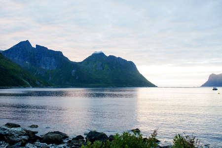 Happy family, standing on a rock and looking over Segla mountain on Senja island, North Norway....