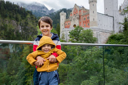 People, enjoying a day in Neuschwanstein castle in Germany, summertime on a cloudy foggy dayの写真素材