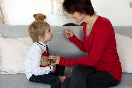 Mother, testing her child for covid at home, making home allowed swab testsの写真素材