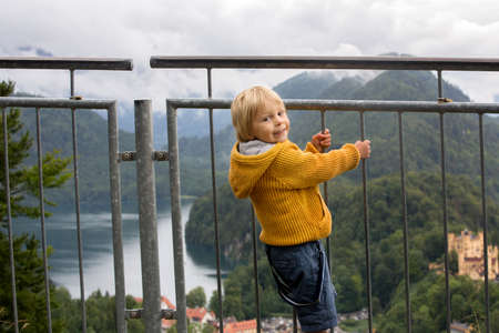 People, enjoying a day in Neuschwanstein castle in Germany, summertime on a cloudy foggy dayの写真素材