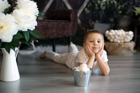 Sweet toddler child, cute boy playing with Easter eggs, Easter decoration in studio, springtime