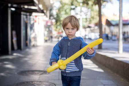 Cute little child tourist, holding balloon made as a sword, admiring Barcelona city, family travel with kids in Spainの写真素材