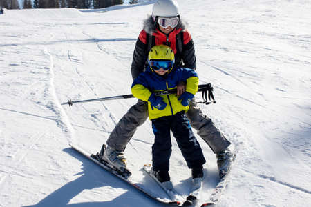 Happy family, skiing in Italy on a sunny day, kids and adults skiing together. Family vacationの写真素材