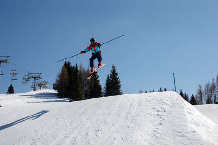 Happy preteen child, jumping with ski in a snow fun park. Kid skiing in Italy on a sunny day, kids...