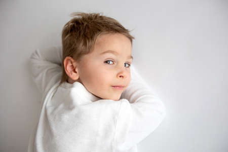 Cute stylish toddler child and older brother, boys with white shirts on white background, family...
