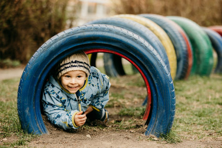 Sweet preschool child, cute boy, playing on the playground in the park, springtimeの写真素材